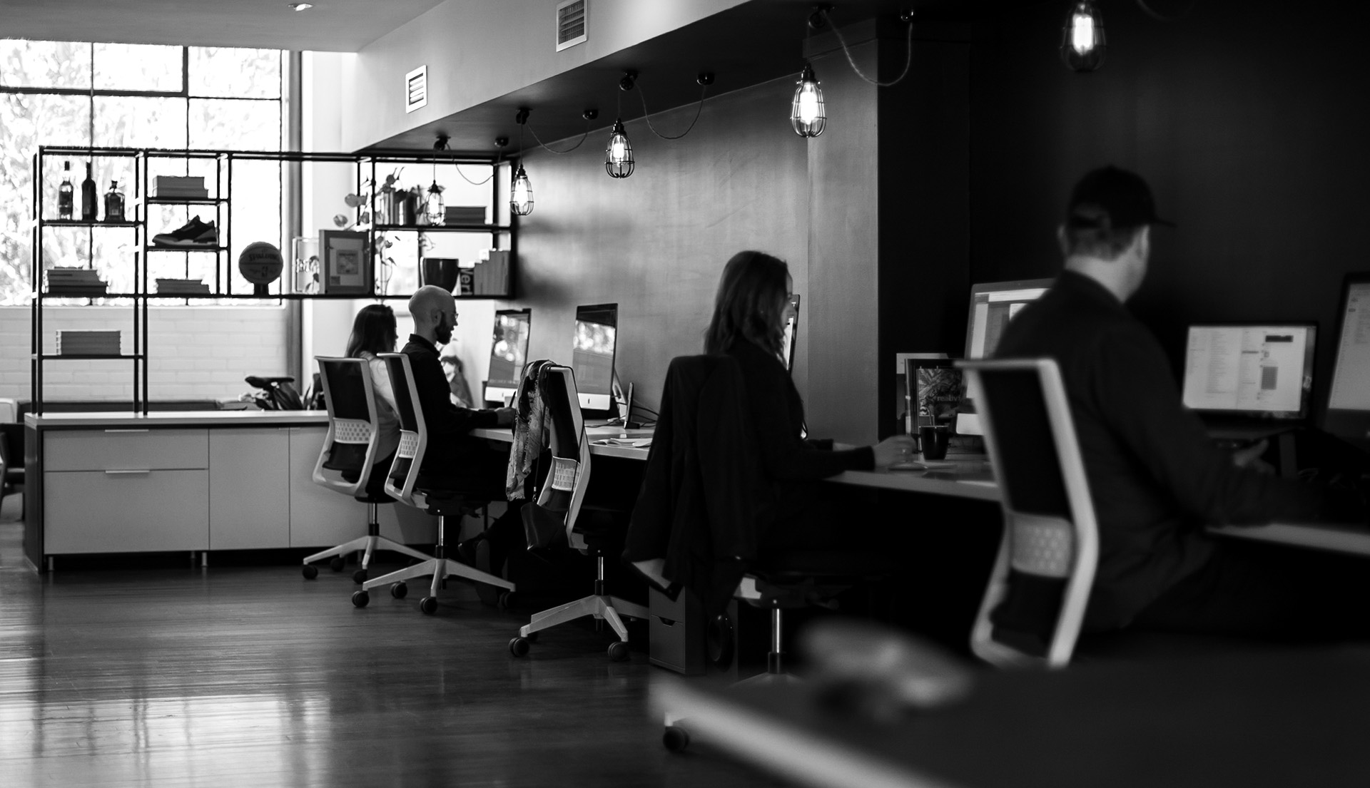 Inside the Inklab studio. Staff working at computers, sunlight coming through window.