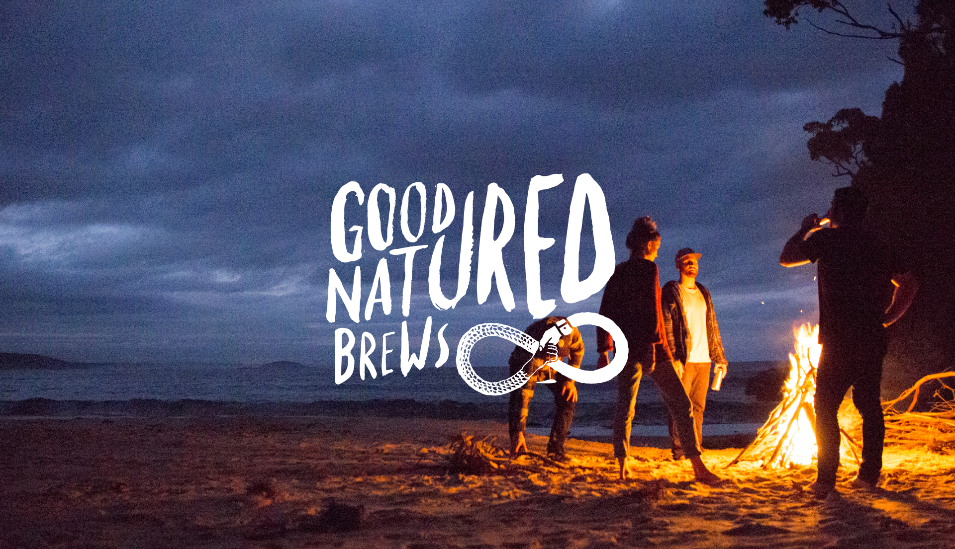 People standing around a bonfire on a beach at night time drinking capital brewing beers. "Good natured Brews" hand lettering overlaid on top of the image.