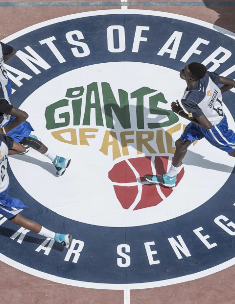 Players running across a Giants of Africa basketball court