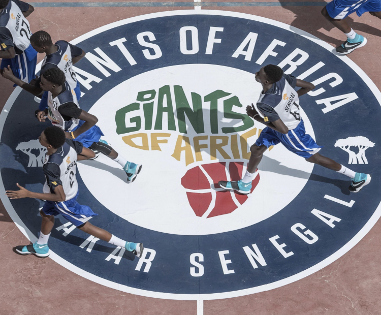 Players running across a Giants of Africa basketball court
