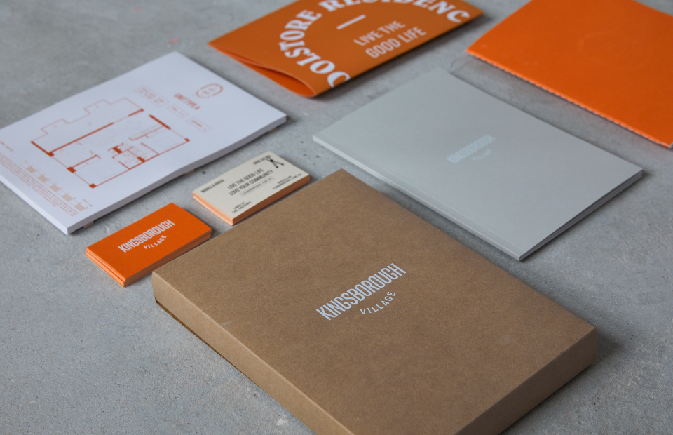Kingsborough branded sales pack flatlay styled photograph. Pack includes floorplans, business cards, poster, and brochures.