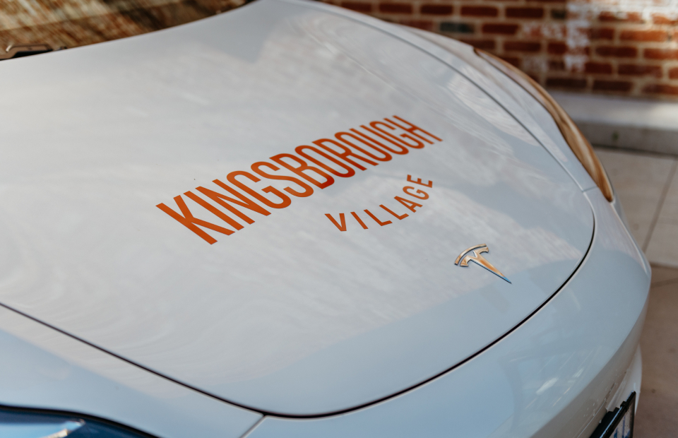 Kingsborough Village logo on hood/bonnet of Tesla.
