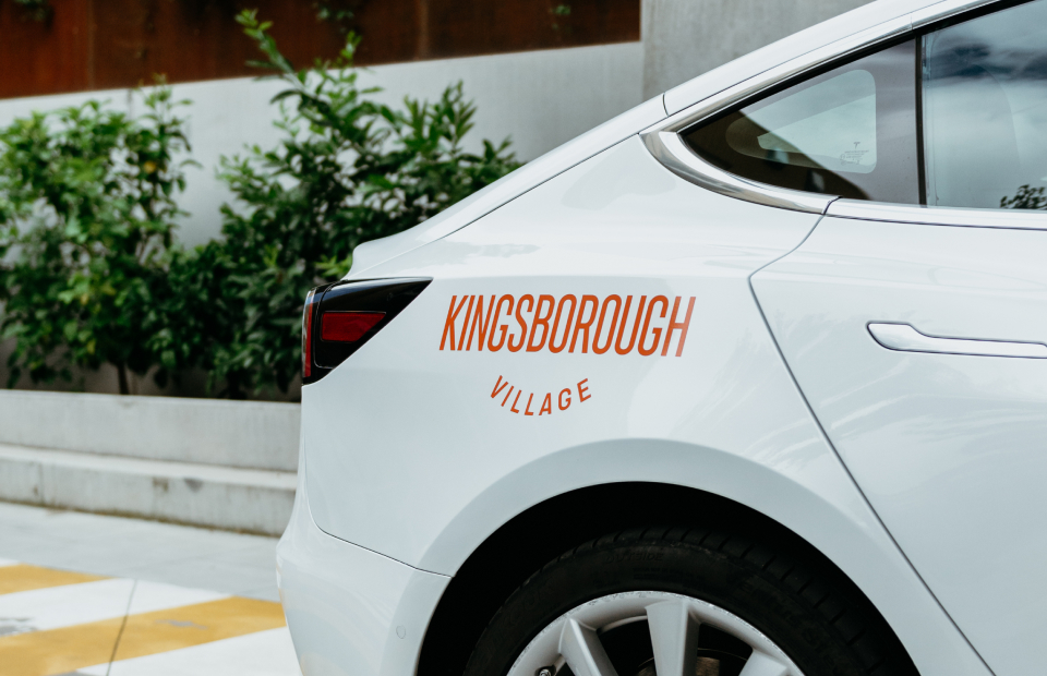 Kingsborough Village logo on side of Tesla.