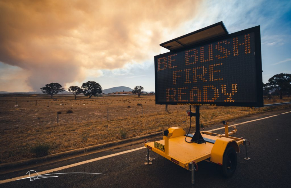 Bushfire smoke in sky, LED road sign that reads, "Be Bushfire Ready"