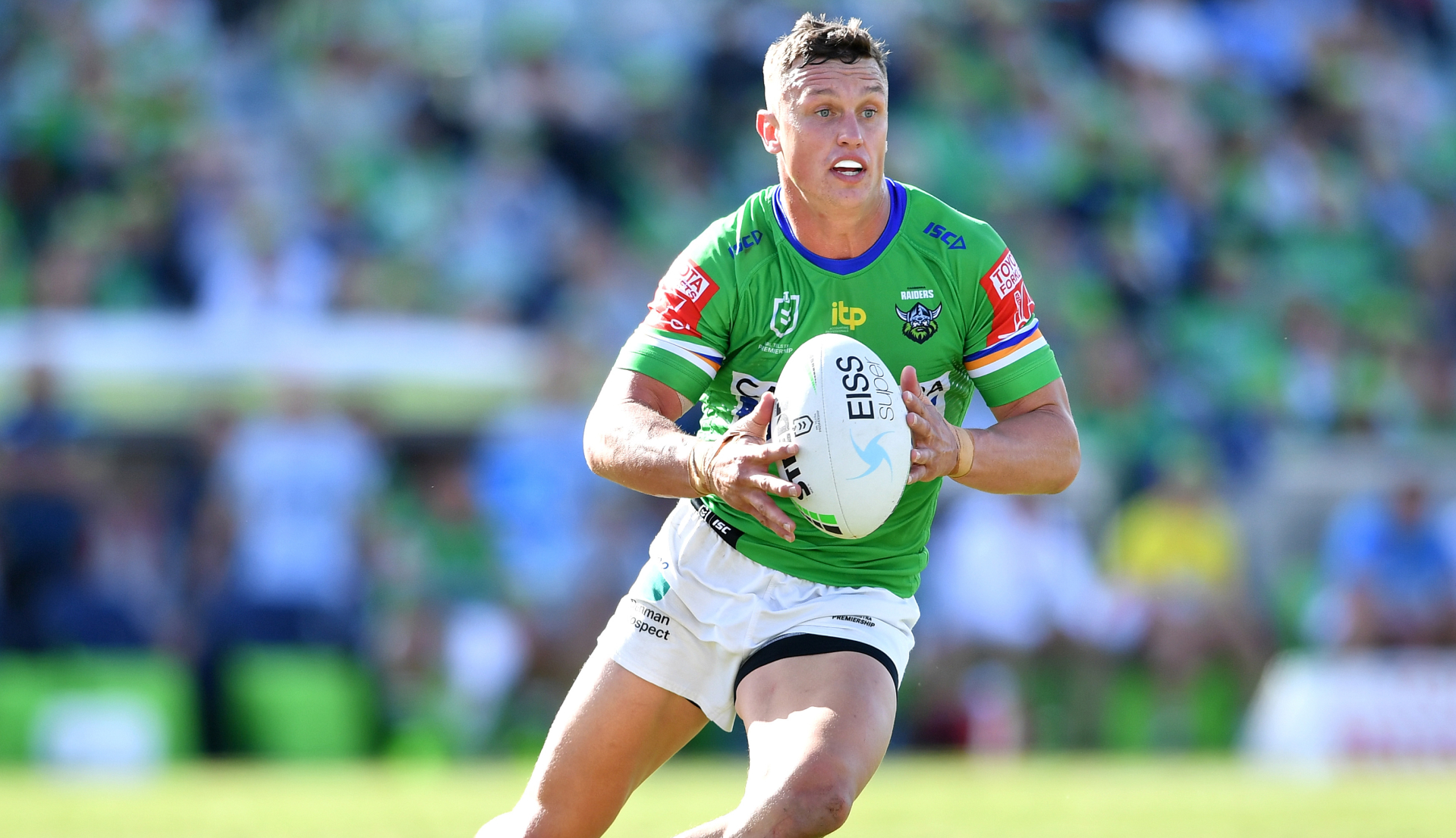 Canberra Raiders player running on field with football