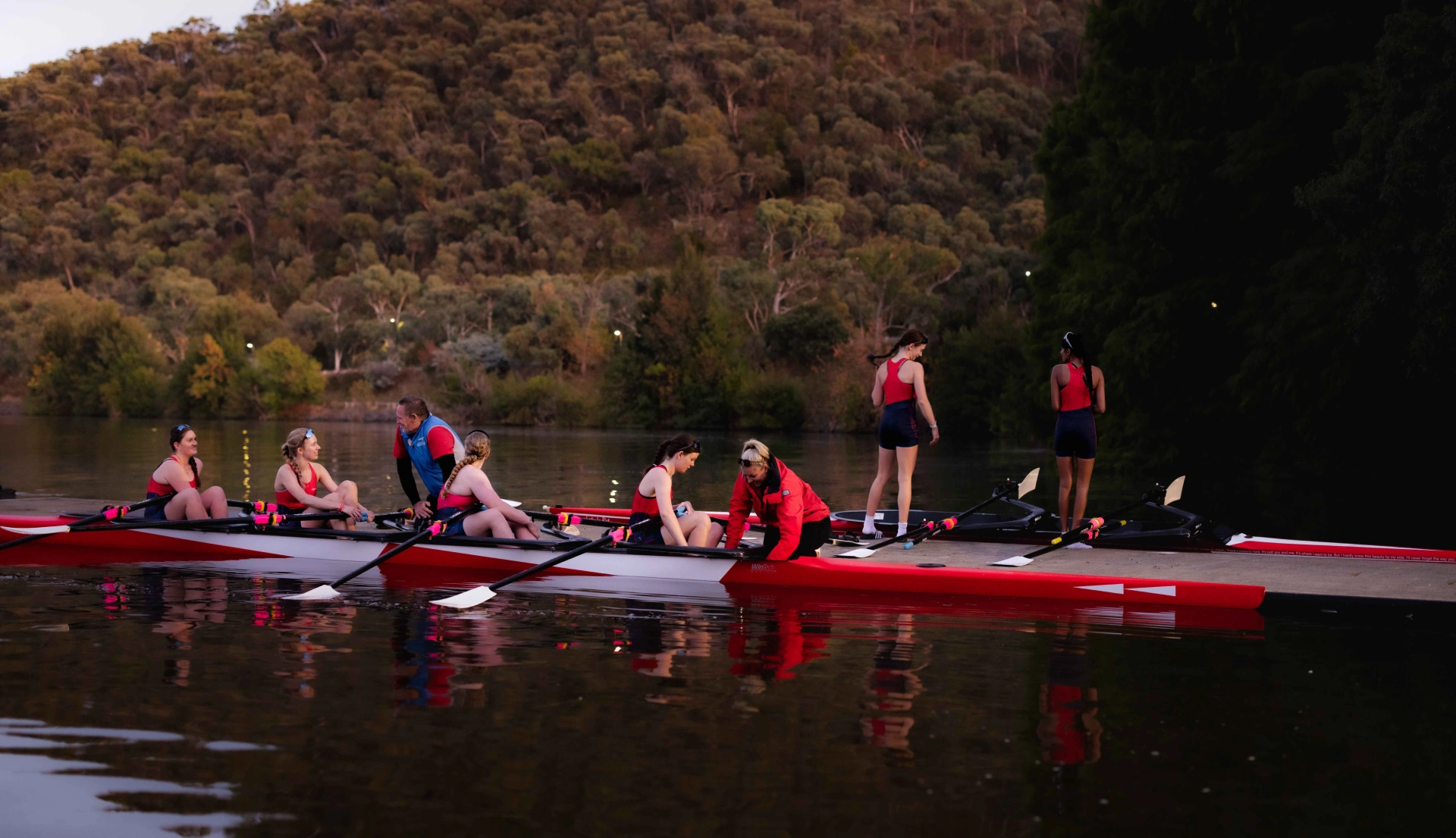 A row team getting boats on water ready for race training.