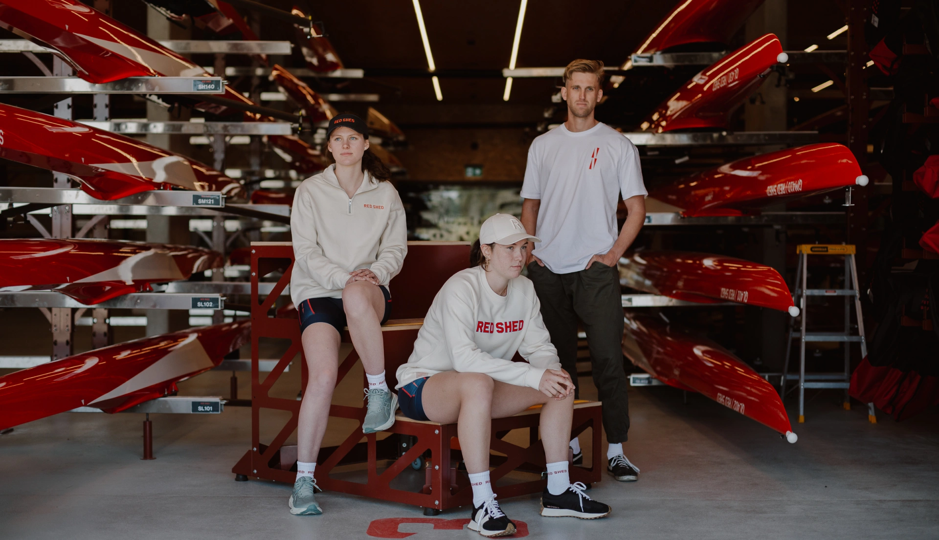 Red Shed merchandise fashion shoot showing three models in various Red Shed gear
